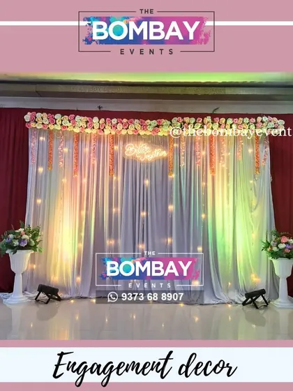 For this engagement ceremony, we designed an elegant stage backdrop using flowing white and red drapes, warm fairy lights, and a beautiful floral arrangement on top. The uplighting adds a touch of drama, making the couple the center of attention.