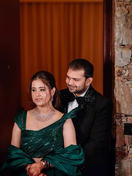 A romantic moment between the couple. The groom's classic black tuxedo perfectly complements the bride's glamorous green gown.