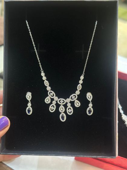 A new luxury necklace and earring set in silver 925. This design features oval-shaped motifs with blue stones, offering an elegant look at a reasonable price.