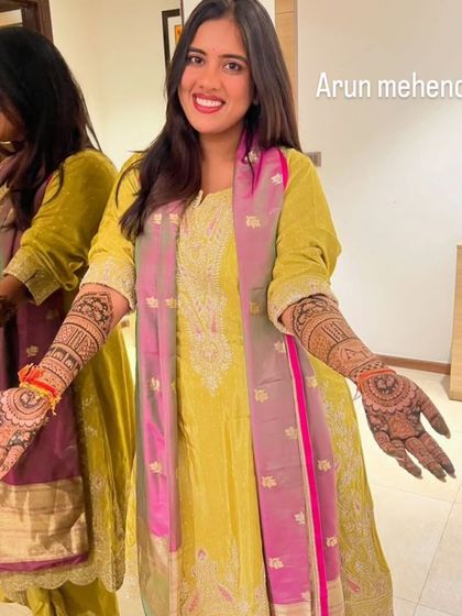 A happy client admiring her reflection and her beautiful mehendi. The rich color comes from my special, homemade natural henna paste.