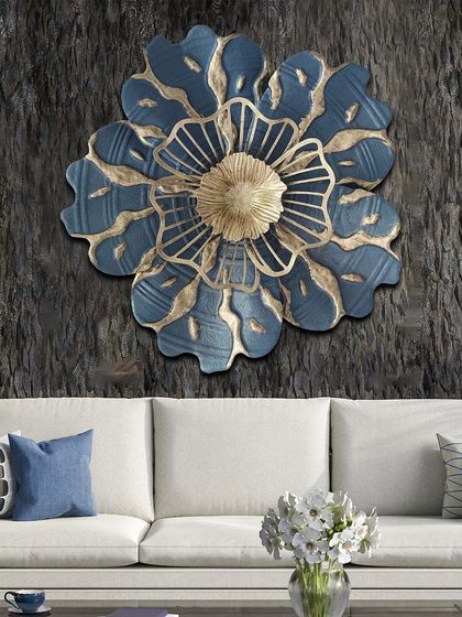 A large, single flower in blue and gold metal. This striking piece of wall art makes a bold statement with its layered petals and intricate detailing, perfect for a contemporary room.
