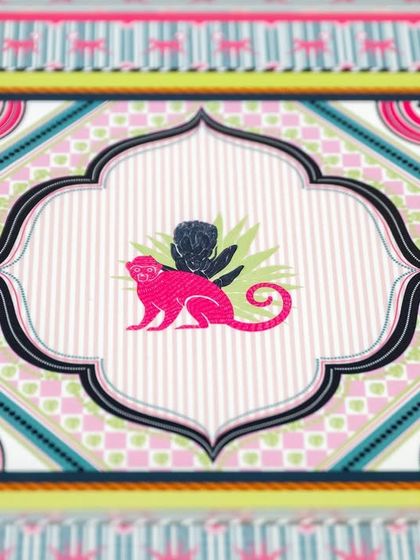 A close-up of the monkey motif from the 'Tropical Tapestry' collection. The combination of bright colours and symmetrical patterns gives it a lively, exotic feel.