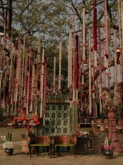 A full view of the magical tree decor, with hanging floral garlands and rustic seating, creating a perfect setting for a fairytale-themed event.