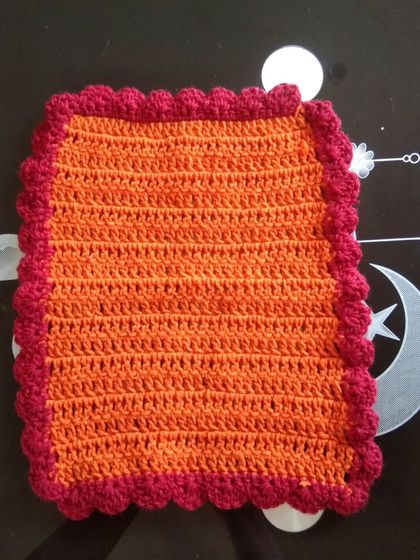 A rectangular table mat in orange and red.