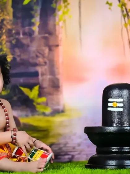 Another beautiful shot of the baby as a Shiva devotee, smiling and playing with a damaru.