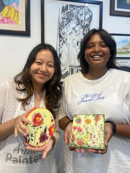 Two friends with their finished decoupage pieces. This versatile craft can be used to decorate a variety of surfaces, from wood to glass.