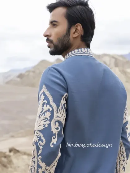 A view of the embroidery on the back and sleeves of the dusty blue kurta.