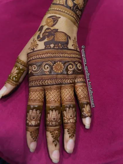 An art that speaks without words. This elegant backhand design features a royal elephant, lotus flowers, and delicate swirls for a timeless and beautiful look.