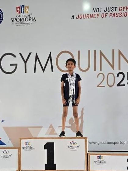 Kayden standing proudly on the winner's podium at the GYMQUINN 2025 gymnastics competition. We nurture all-round champions.