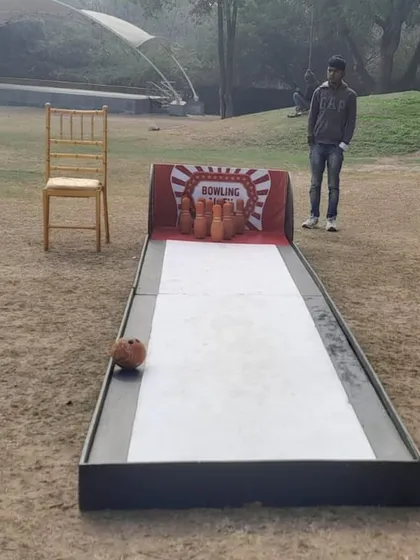 The portable bowling alley game set up at an outdoor venue. It's a great, casual game for guests to play at their own pace during a party.