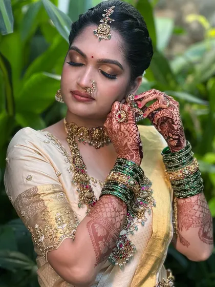 The beauty is in the details. This close-up showcases the harmony between the kohl-lined eyes, the intricate henna, and the traditional temple jewellery, all part of creating a complete and authentic South Indian bridal look.