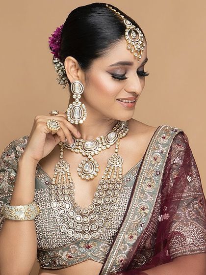 We believe in craftsmanship that tells a story. This close-up highlights the stunning Polki and Kundan-style jewellery that we offer to complement our custom and rental outfits, completing your bridal look.