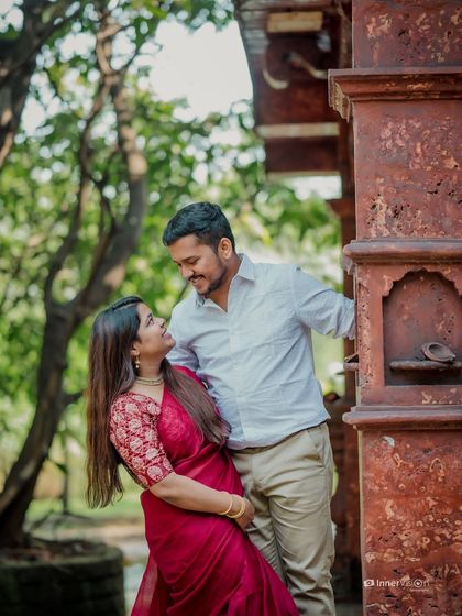 The couple shares a loving gaze by the intricate architecture of a temple. This shot captures a quiet, intimate moment during their traditional pre-wedding shoot.