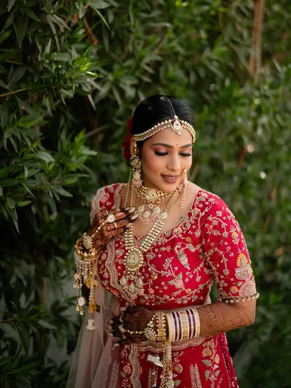 A detailed shot of the bride adjusting her kaleeras, showcasing the intricate jewellery and flawless makeup.
