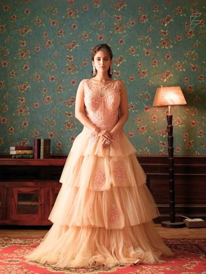 This peach tiered gown offers a modern and romantic look. The layers of tulle create beautiful volume and movement, making it a dream to wear.