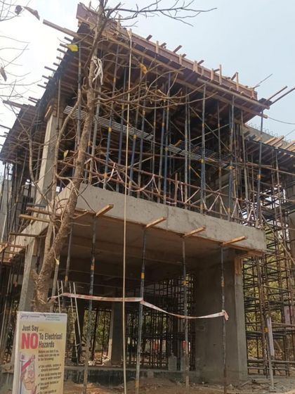 The structural skeleton of a villa under construction, wrapped in scaffolding. This raw image shows the 'bones' of the building before the facade and finishes are applied, a critical stage where the architectural form becomes tangible.