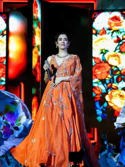 A beautiful shot of a performer on stage, framed by vibrant, stained-glass-style LED visuals. We create custom visual content that complements the artist's attire and the mood of the song.
