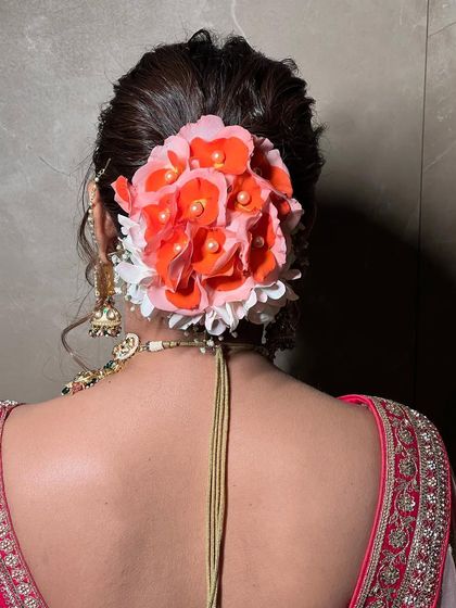 The detail on this fresh flower arrangement for a bridal bun. The combination of colors and textures makes the hairstyle a central part of the bridal look.