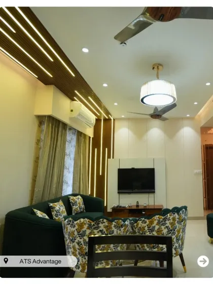 This living room design uses vertical wood and light strips to create a sense of height and drama. The green sofa with floral chairs adds a touch of nature-inspired elegance.