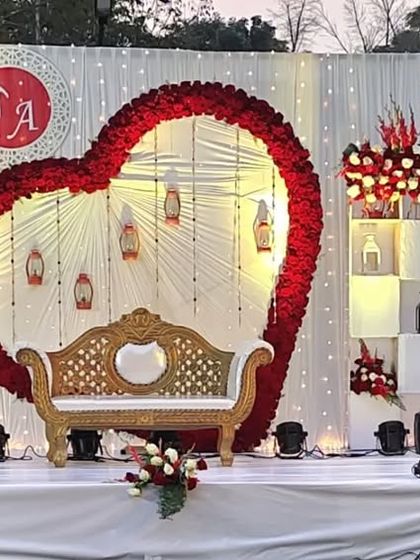 A romantic heart-shaped floral arch frames the seating for this engagement ceremony, using red and white roses to create a classic symbol of love.