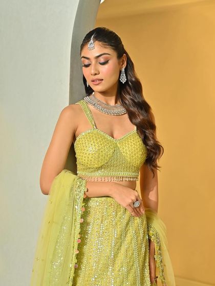 The soft waves beautifully complement the bride's sparkling lime green lehenga and diamond jewelry.