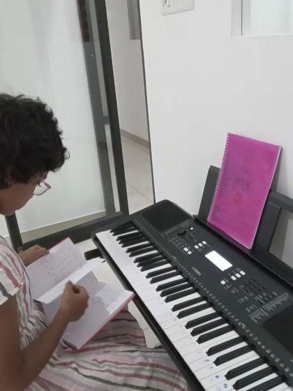 A student reviewing her notes before practicing on the keyboard. We encourage good practice habits.