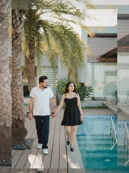A lovely shot of a couple walking hand-in-hand along a poolside deck, framed by palm trees, creating a relaxed, resort-style vibe.