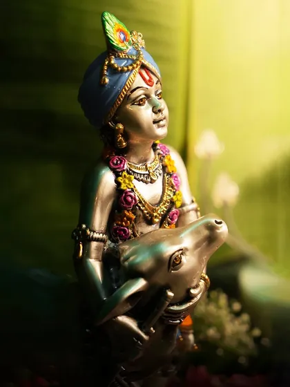 The divine charm of Lord Krishna is captured in this beautifully crafted silver-plated idol. The soft lighting accentuates his gentle expression and the loving presence of the calf, making it a perfect piece to celebrate Janmashtami or bless a new home.
