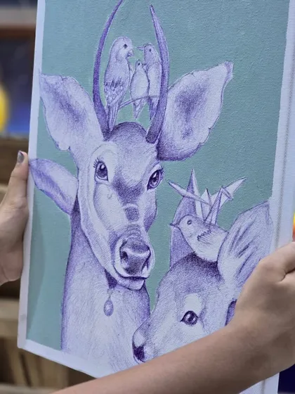 Holding up the finished piece. This image shows the beautiful details of the completed ballpoint pen drawing of two deer with birds.