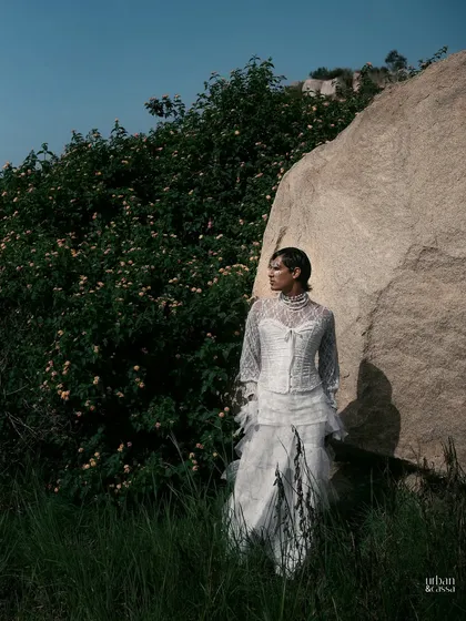 This shot captures the ethereal quality of the look, with the model appearing almost like a spirit in the natural landscape.