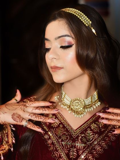 This pose highlights the intricate necklace and the delicate henna patterns on her hands. It's a perfect shot for capturing the details of bridal jewelry and makeup.