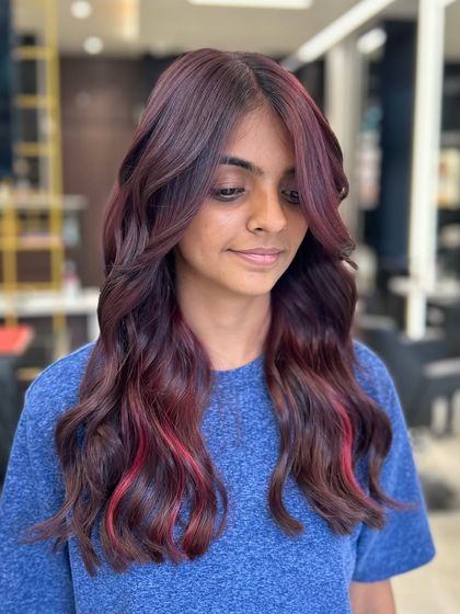 Embracing the rich and vibrant vibes of this vine hair color. The peekaboo pink highlight adds a playful and unique touch to the overall look.