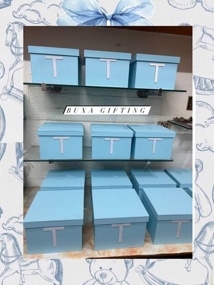 A collection of Baby Dior inspired centerpiece boxes, ready for a luxury baby celebration. The clean lines and monogram make for an elegant statement.