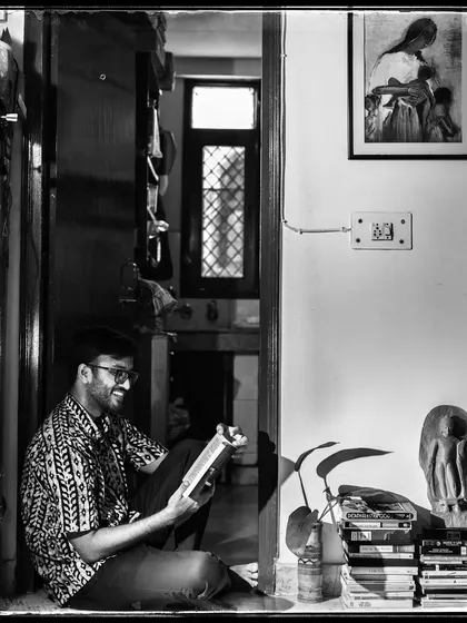 Arko, reading on the floor, surrounded by books and art. A portrait of a creative soul in his natural habitat.