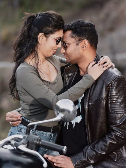 A close-up, intimate portrait of a couple on their bike. This shot focuses on their connection and affection, showing that even an adventurous theme can have soft, romantic moments.