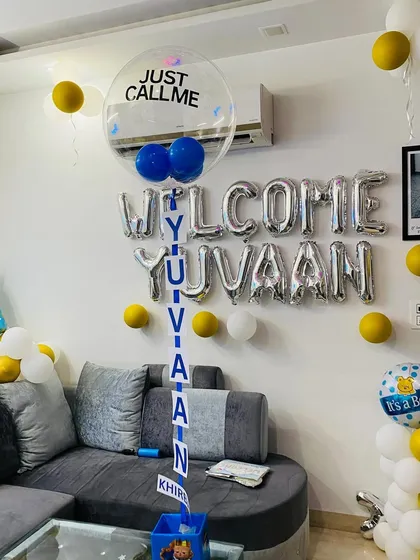A simple yet sweet living room setup to welcome baby Yuvaan, with silver foil balloons and a personalized name reveal balloon.