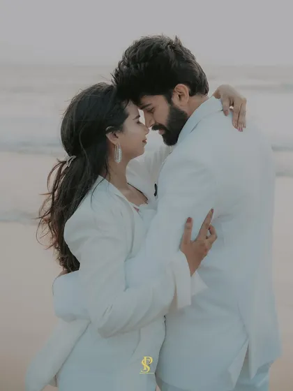 An intimate portrait of the couple on the beach at dusk. The soft light and their close embrace create a deeply romantic and timeless image.
