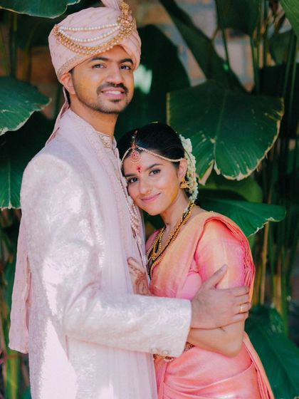 A warm and loving embrace against a backdrop of lush green leaves. This portrait feels natural and comfortable.