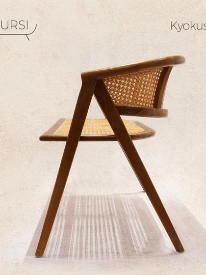 The 'Kyokusen' chair, a chic and comfortable piece with a unique Z-shaped profile. The seat and back are made of handwoven cane set in a solid teak frame.