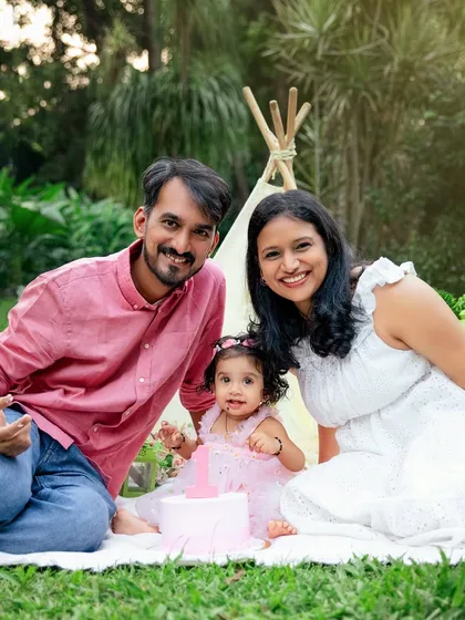 A happy family enjoying a garden cake smash picnic. This photo shows how I can combine a cake smash with beautiful family portraits for a complete birthday celebration.