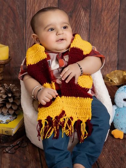 The look of wonder on this little wizard's face is just priceless. My studio is filled with props like this Gryffindor scarf, vintage globe, and candles to create an authentic magical atmosphere.