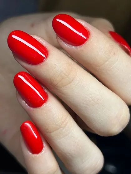 A classic, bright red manicure on oval-shaped nails. A timeless choice that is always vibrant and stylish.