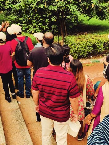 A behind-the-scenes look at our Lalbagh walk, as the group gathers to learn about a specific botanical specimen from our expert guide.