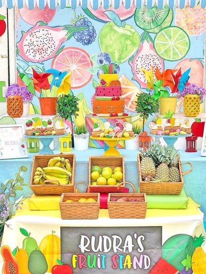 A custom fruit stand for a "one in a melon" birthday. The colorful backdrop and fruit-themed cake were the centerpiece of this fresh and fun party.