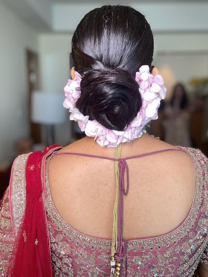 A sleek and clean bridal bun adorned with a full arch of light pink hydrangeas. This style is incredibly romantic and photographs beautifully.