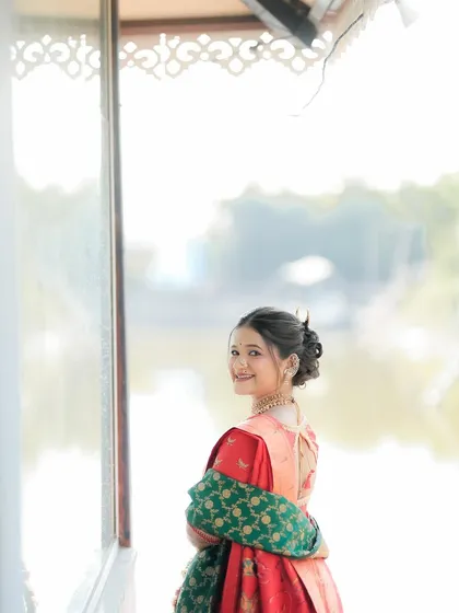 A lovely, candid shot of a bride looking back with a smile. Her mehndi-adorned hands add to the grace and beauty of the moment.