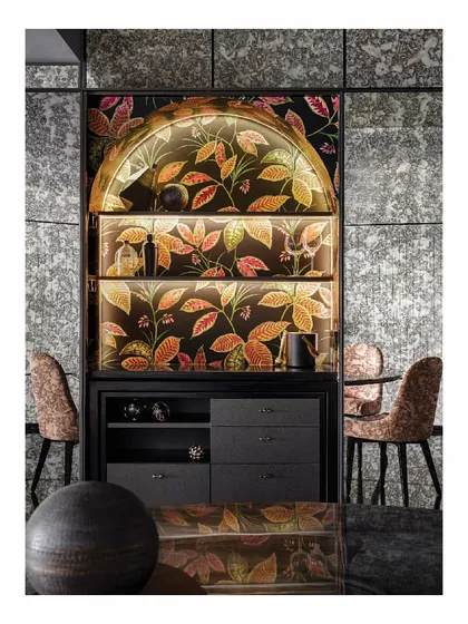 This discreet home bar is hidden behind a mirrored wall, clad in a funky, vibrant wallpaper. When the doors are closed, it becomes inconspicuous, but when open, it reveals a perfect setup for house parties, blending function with an element of surprise.