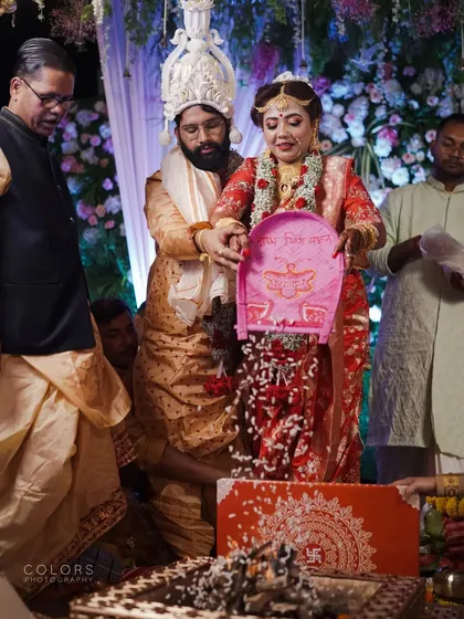 A traditional Bengali wedding ritual, where the couple participates in the 'kanak anjali' ceremony.