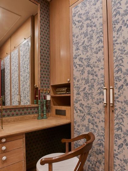Prints can transform any space, including a dressing room. Here, I used a beautiful floral and bird print fabric on the wardrobe shutters to add a layer of softness and personality, proving that even storage can be a design statement.