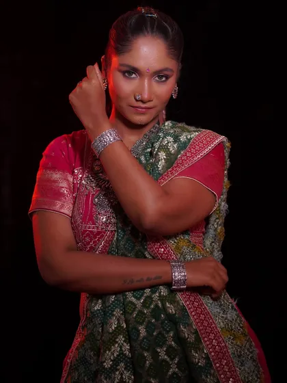 A powerful pose showing the complete look, from the braided hairstyle to the traditional attire.